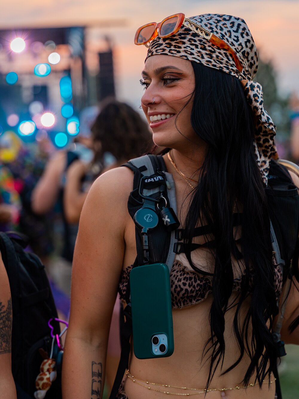 Festival outfit with a green ClutchLoop on a backpack strap